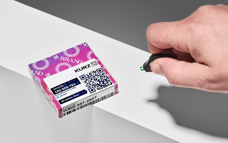 Kleine Lebensmittelverpackung mit TTR Unique UV Sicherheitsetikett, das mit Hilfe des Handscanners verifiziert wird
